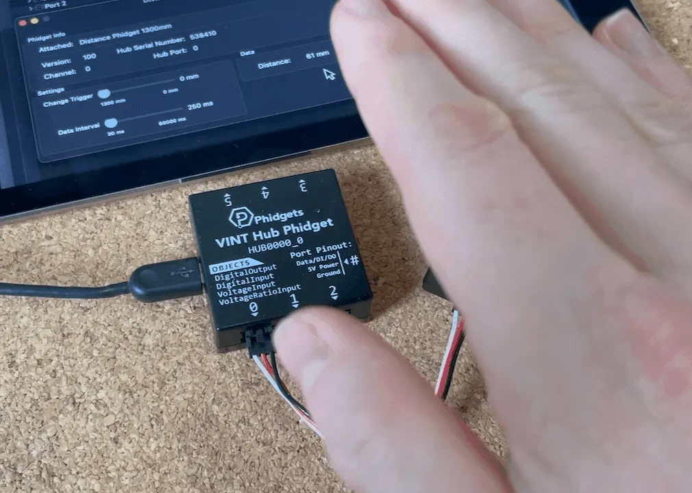 Hand moving closer and further away from distance sensor with the distance changing in the control panel